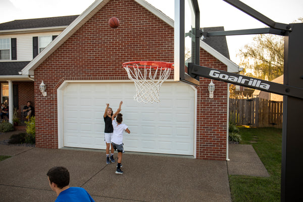 athletes playing on outdoor basketball overhang on court  
