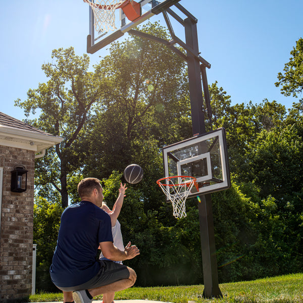 dad and child playing on childrens basketball hoop 