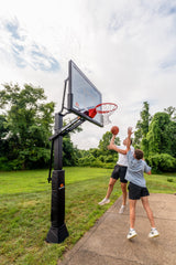 Two people playing basketball outdoors with a Goalrilla CV60T basketball hoop.