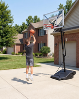 Person playing basketball in front of a house with a basketball hoop