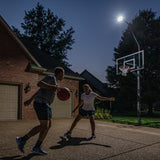Basketball players playing at night with Goaliath LED hoop light