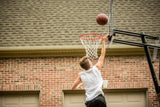 Silverback Portable Basketball Hoop - Boy Shooting Basketball on Home Court