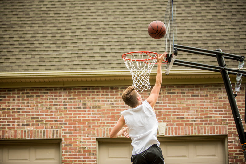 Silverback NXT 50 Portable Basketball Goal - Boy Shooting Basketball on Home Court